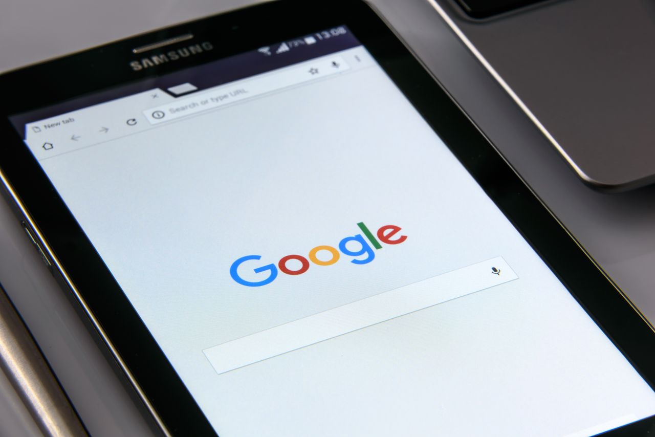Gros plan sur une tablette affichant l’écran de recherche de Google, mettant en avant la technologie et la navigation sur internet.